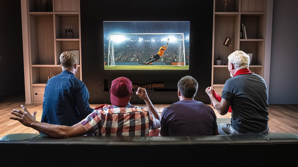 4 personas viendo deporte en el sofá