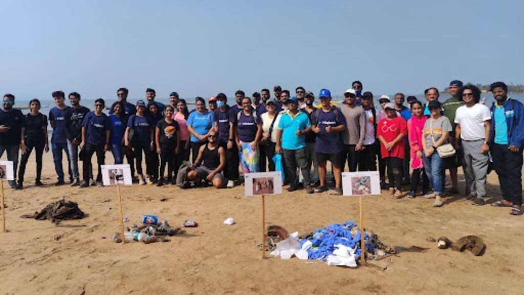 Grupo de voluntarios en la playa posando junto a la basura recogida