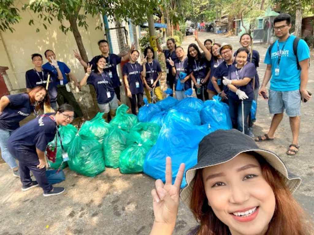 Eine Gruppe von Freiwilligen posiert neben gesammeltem Müll