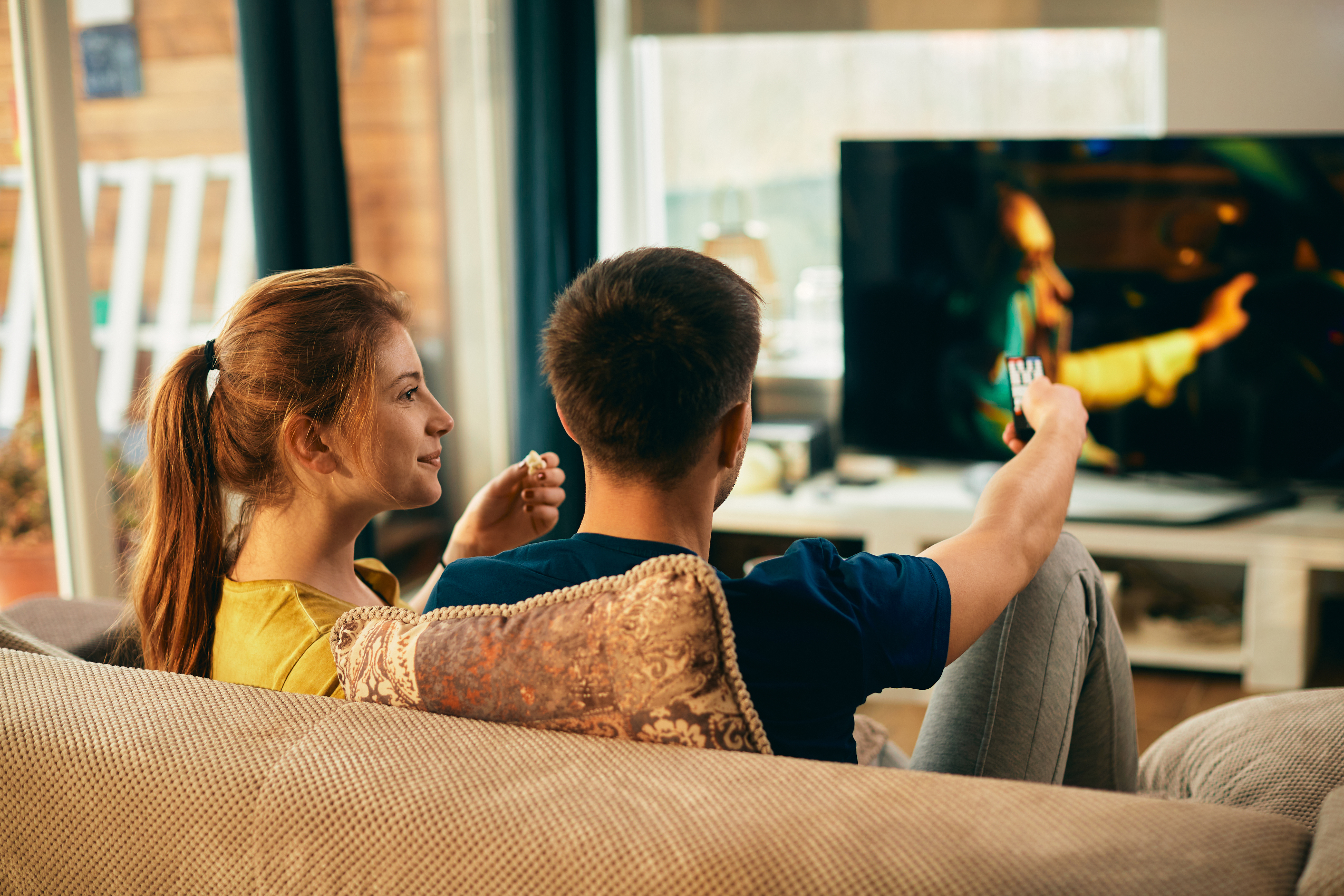 Para relaksująca się na sofie i oglądająca telewizję