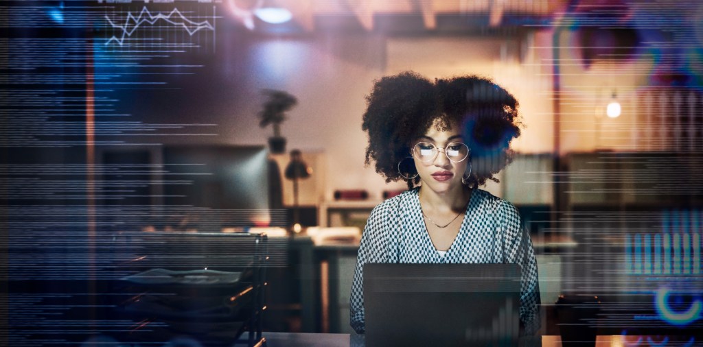 Uma mulher negra olhando para o laptop e pesquisando dados