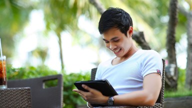 Hombre mirando a Tablet y sonriendo